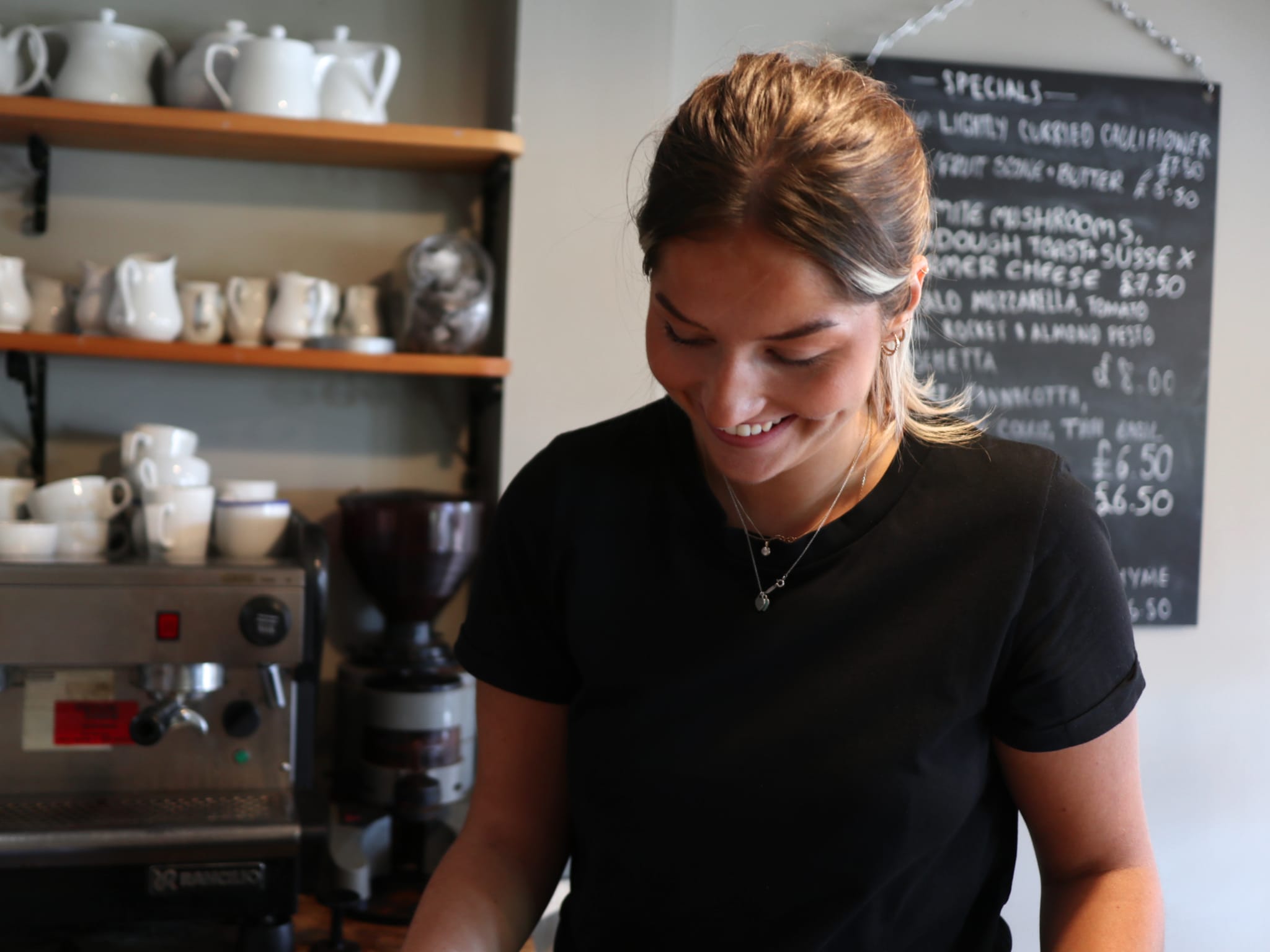 Frankie smiling and serving coffee.